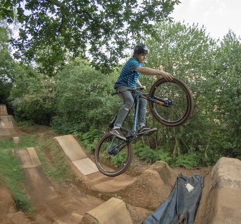 man riding a mountain bike, in the air mid jump performing a trick